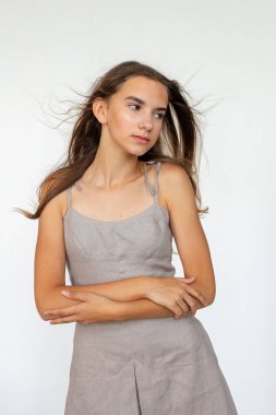 Kollarını kavuşturmuş stüdyo portresi, gri elbise, modern minimal moda ve kopyalama alanı