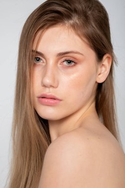 Kapalı portre, çıplak omuzlar, yumuşak ifade ve temiz stüdyo estetiği..
