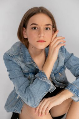 Kot ceketli sıradan bir portre, düşünceli bakışlar, temiz stüdyo estetiği..