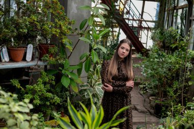 Serada yemyeşil bir yerde poz veren kadın, doğal ışık ve ekolojik yaşam tarzı..