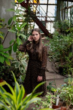 Sera koridorunda dikey portre, bitkiler arasında kadın, asgari doğa estetiği..