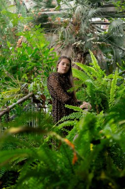 Yeşillik, sakin ifade, tropik sera havası arasında tüm vücut portresi.