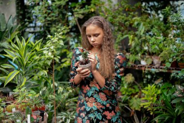 Tropik yeşilliklerin, botanik serasının estetik ve yavaş yaşam konseptinin arasında poz veren kadın..