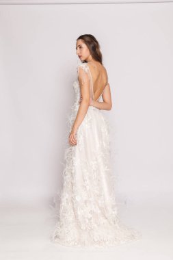 Gelin tarzı stüdyo pozu, beyaz elbise, dantel detaylar, modern gelin koleksiyonu..