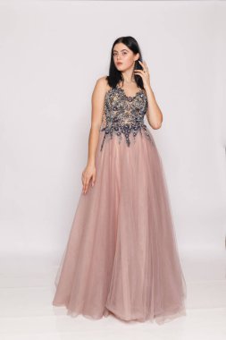 Full-length pose in mauve gown, minimalist white background, boutique evening dress.