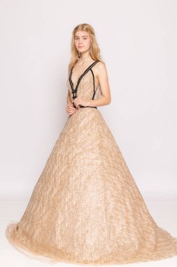 Yan pozda siluet ve etek hacmini, stüdyo resmi kıyafet için arama kitabını gösteriyor..