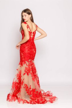 Uzun boylu poz, kırmızı dantelli elbise, moda kampanyası görünüşü, temiz stüdyo.