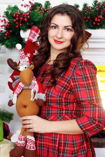Chica en un vestido rojo cerca del árbol de Navidad — Foto de Stock