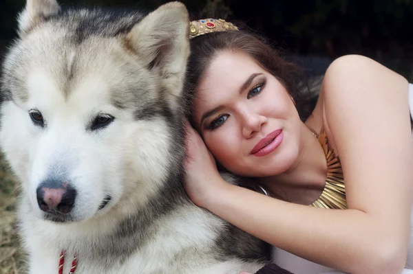 Jovem mulher com cão lobo na neve — Fotografia de Stock