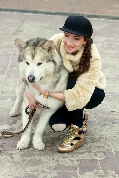 Junge Frau mit Wolfshund im Schnee — Stockfoto