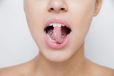 Beautiful woman sticking out her tongue and showing young piercing clipart