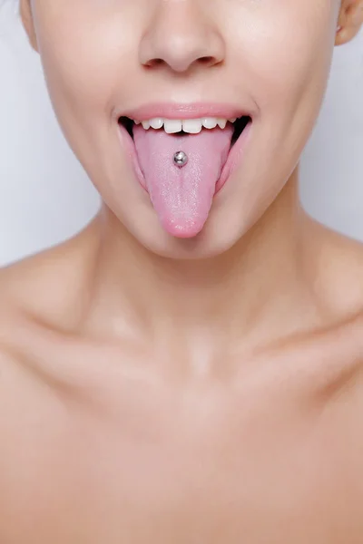 Mulher bonita saindo de sua língua e mostrando jovem piercing — Fotografia de Stock