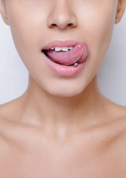 Hermosa mujer sacando la lengua y mostrando un piercing joven —  Fotos de Stock