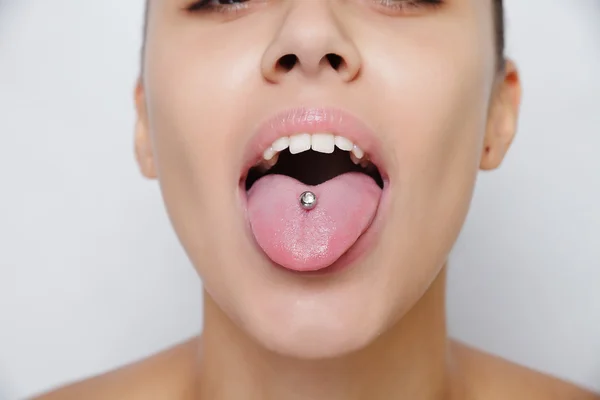 Mulher bonita saindo de sua língua e mostrando jovem piercing — Fotografia de Stock