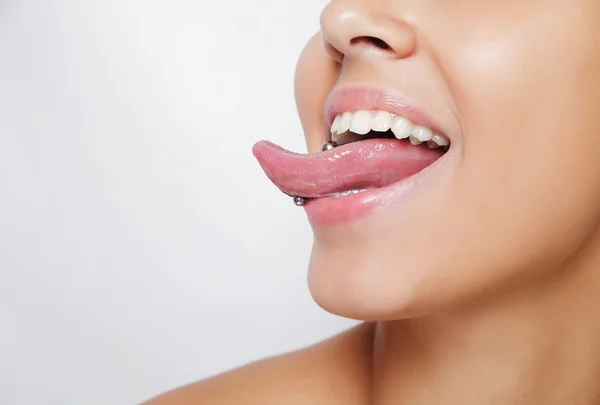 Hermosa mujer sacando la lengua y mostrando un piercing joven — Foto de Stock