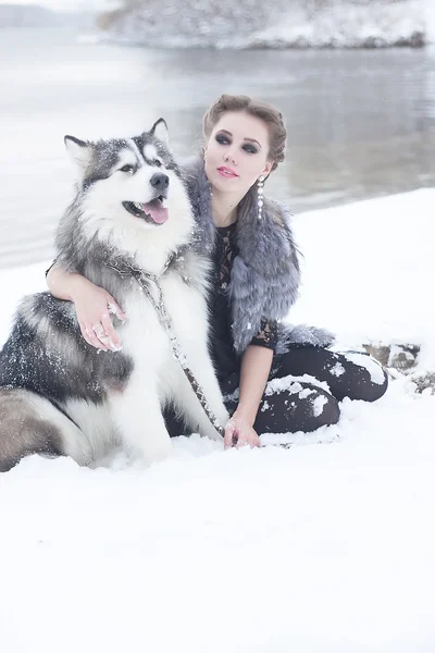 Jeune femme avec chien loup dans la neige — Photo