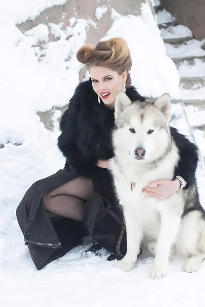 雪の中でオオカミ犬を持つ若い女 — ストック写真
