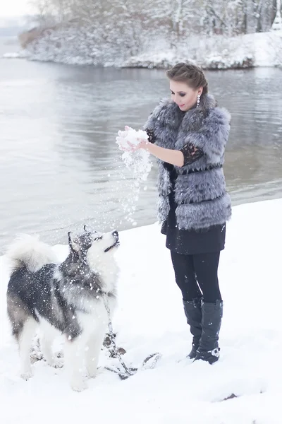 Jeune femme avec chien loup dans la neige — Photo