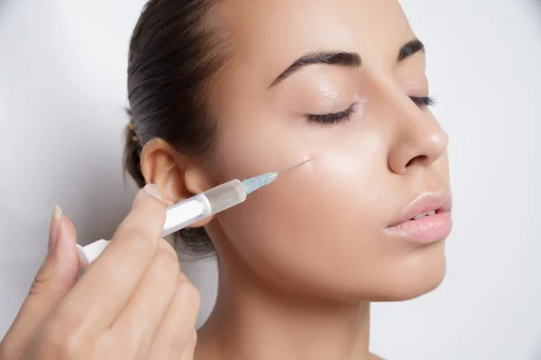 Retrato de mujer caucásica joven recibiendo inyección cosmética — Foto de Stock