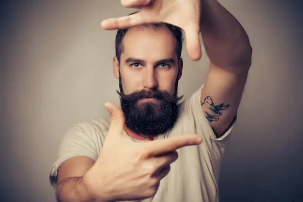 Jovem fotógrafo alegre com barba, enquanto trabalhava em estúdio — Fotografia de Stock