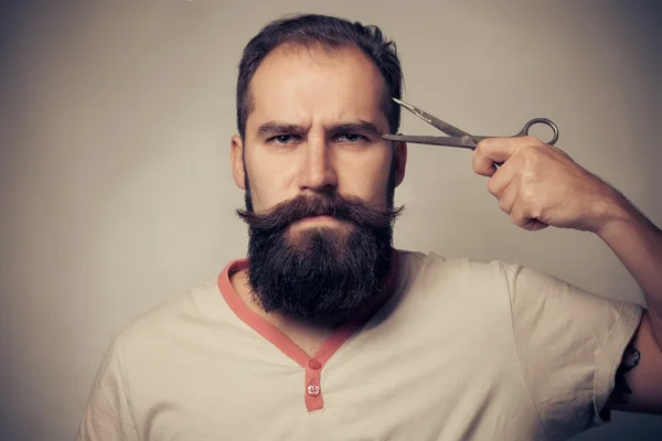 Homem Barba de corte contra um fundo cinza — Fotografia de Stock