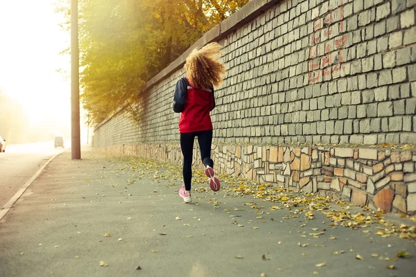 Девочка бежит на закате в центре города — стоковое фото