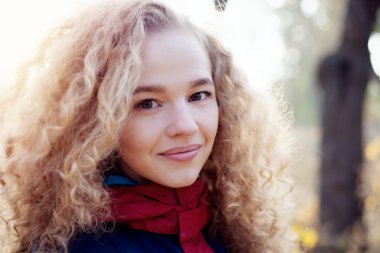 Portre gülümseyen neşeli genç kadın kıvırcık saçları açık havada kapatın