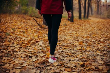 Gün batımında sonbahar turuncu ormanda çalışan fitness kız