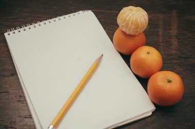 Mandalina defter kalem kahve eski ahşap zemin üzerine