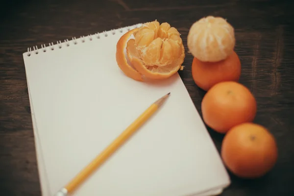 Cuaderno de mandarinas café lápiz sobre fondo de madera viejo —  Fotos de Stock