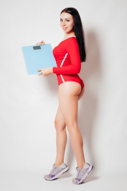 Diyet ve egzersiz portre tutan genç fitness kadın mutlu bir şekilde ölçeklendirir 