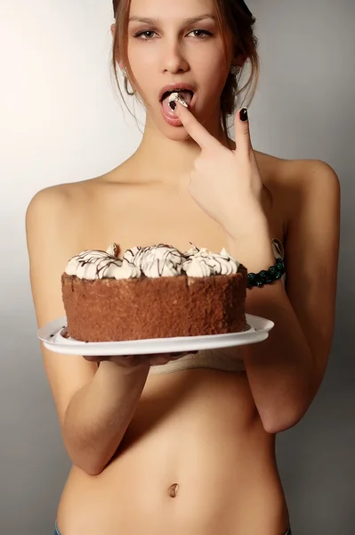 Busty sexy girl eating cake with whipped cream — Stock Photo, Image