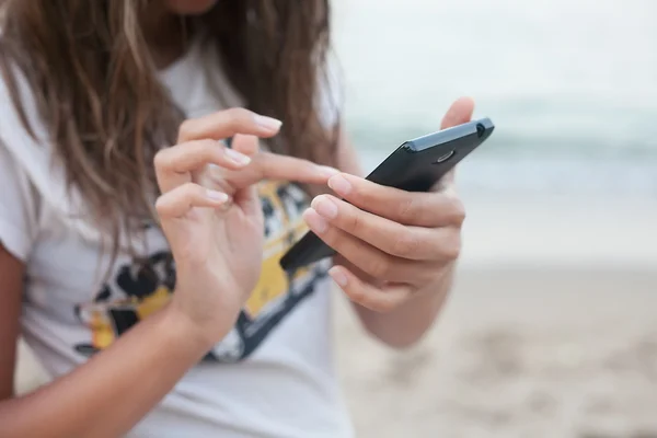 Kırpılmış görüntü kadının holding akıllı telefon deniz arka plan eller