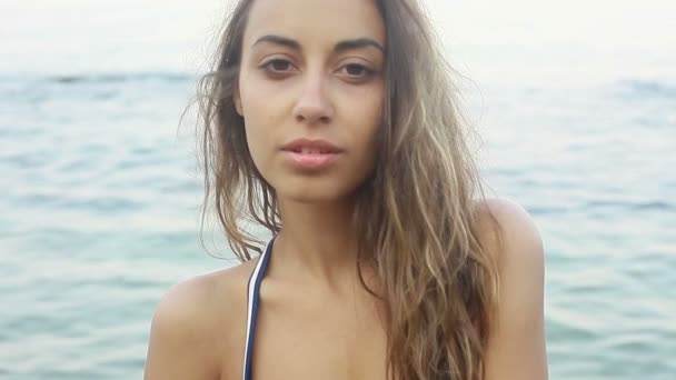 Portrait de mode en plein air de femme brune sexy fille sportive posant avec une vue sur la mer, lentement. en maillot de bain bleu, journée ensoleillée . — Video