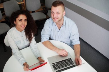 Dizüstü bilgisayar ile masanın iki ciddi genç iş adamları 