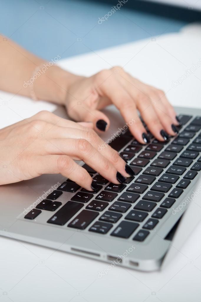 Closeup portrait of woman's hand typing on computer keyboard