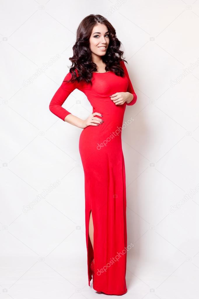 Beautiful woman in long red dress healthy curly hair standing