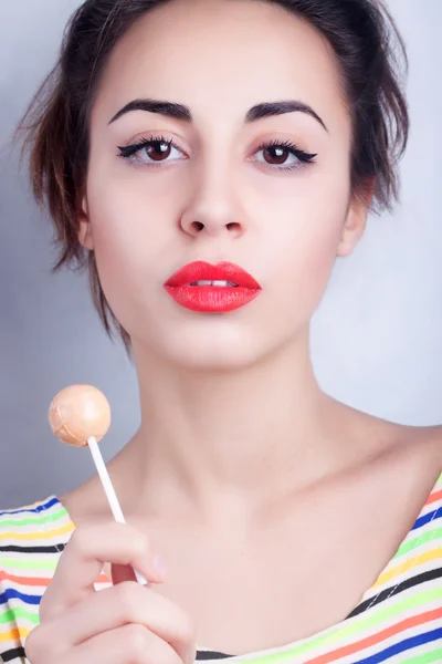 Primer plano retrato morena mujer con labios rojos caramelo palo — Foto de Stock