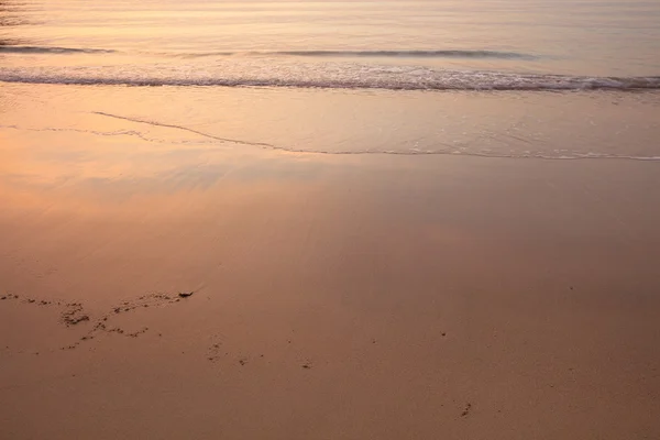 Glödande solnedgången i havet. Himlen speglar i vatten och sand — Stockfoto