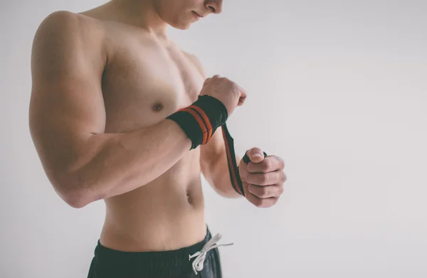 Hombre con torso muscular. Primer plano de un joven musculoso levantando pesas — Foto de Stock