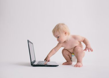 beyaz izole bir dizüstü bilgisayar ile oynarken sevimli bebek