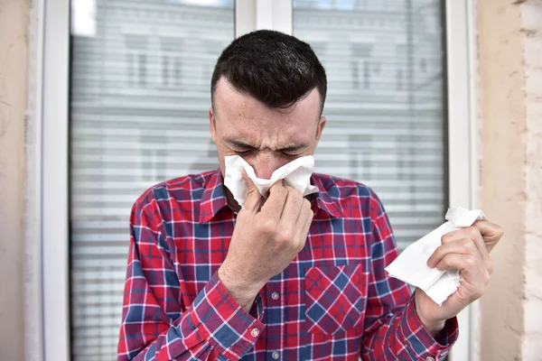 Imagen de un joven con pañuelo. El enfermo tiene secreción nasal. cura el resfriado común — Foto de Stock