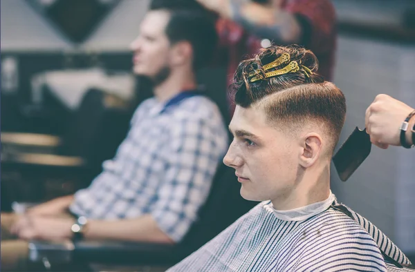 Fryzjer sprawia, że fryzura człowiek z klipsem na głowie w salonie fryzjerskim — Zdjęcie stockowe