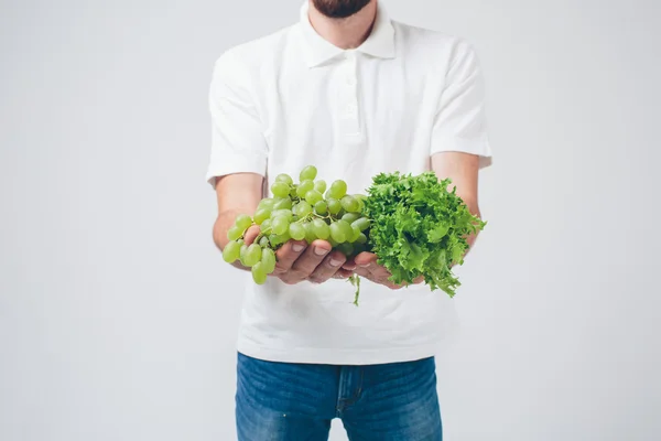 Homem segurando saladas e uva, de perto. conceito. isolado em branco — Fotografia de Stock