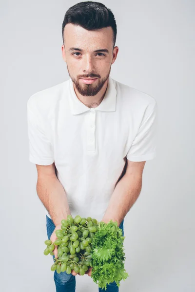Muž držící saláty a hrozny, zblízka. koncepce. izolované na bílém — Stock fotografie