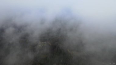 Dağların tepesinde bulutlar arasında uçuyor. Yüksek tepeler, harika sabah güneşi, doğal manzara.