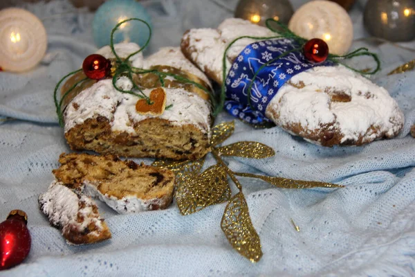 Christstollen und Plätzchen mit Apfelglühwein und Weihnachtsbeleuchtung. Traditionelle süße Fruchtlaibe mit Puderzucker. — Stockfoto