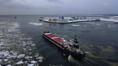 Denizdeki ultra büyük kargo gemisinin hava görüntüsü gün batımında limandan ayrılıyor. Tankerin arka tarafındaki insansız hava aracı görüntüleri. Ulaşım lojistiği, denizcilik kavramı.