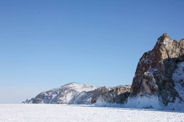 Manzara mavisi şeffaf buz Gölü Baykal. Yüzeyde pürüzsüz derin çatlaklar. Turistler seyahat eder. Sinematik Yüksek Dağlar kar kayalığı. En iyi Rusya Buryatia. Kış günü mavi gökyüzü. Yukarıdaki Gökyüzü.