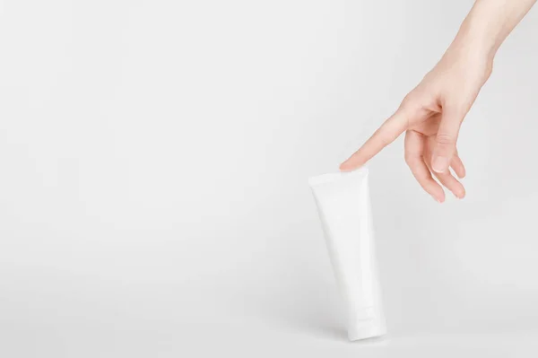 Kadın el krema için flakon 'a dokunuyor. Vücut losyonu ve tuvalet malzemeleri için konteynır. Profesyonel bakım ürünleri için tüp. Cilt bakımı ve reklam konsepti. Model stili ve kopyalama alanı. Gri renkte izole edilmiş.